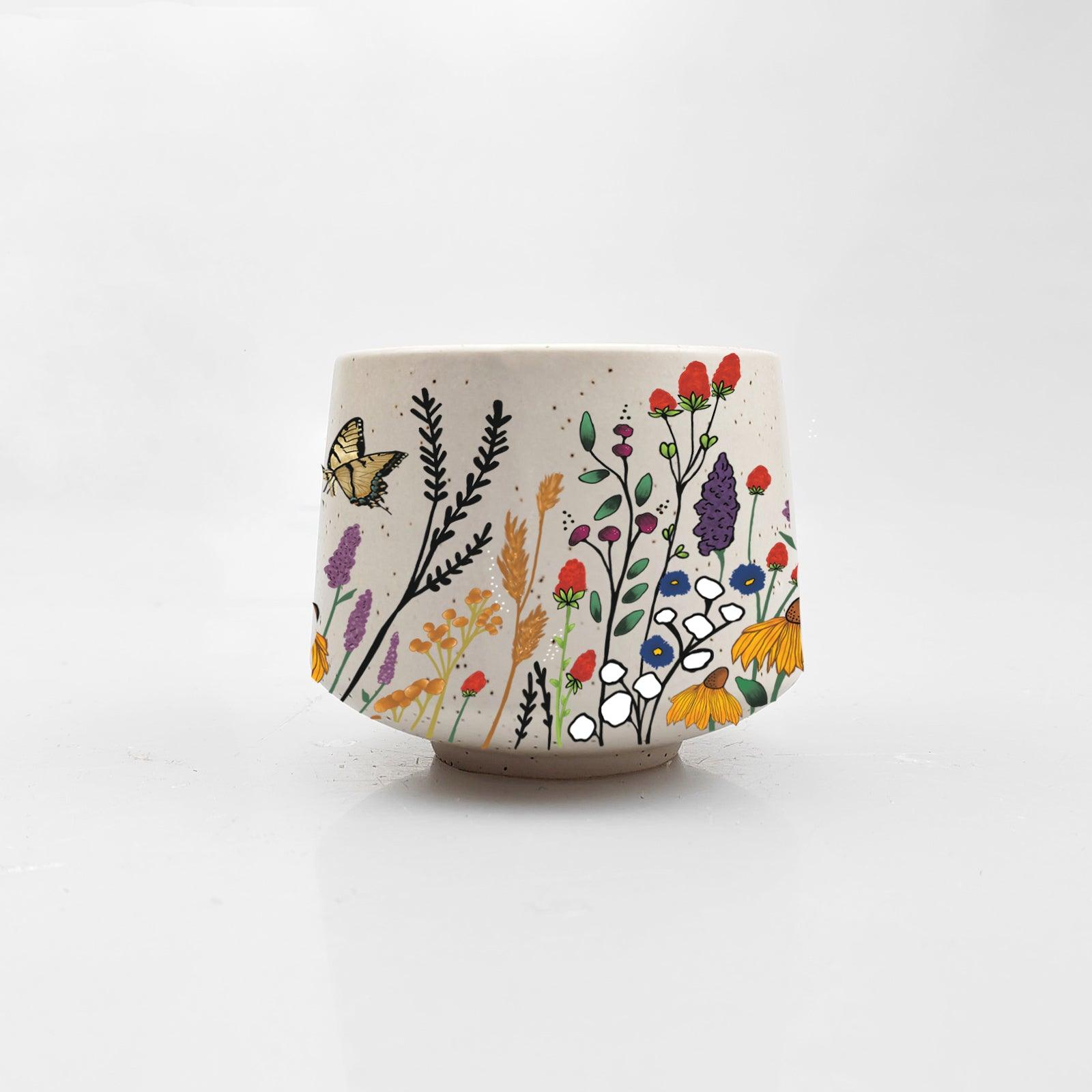 Ceramic cup with floral and butterfly design on a white background