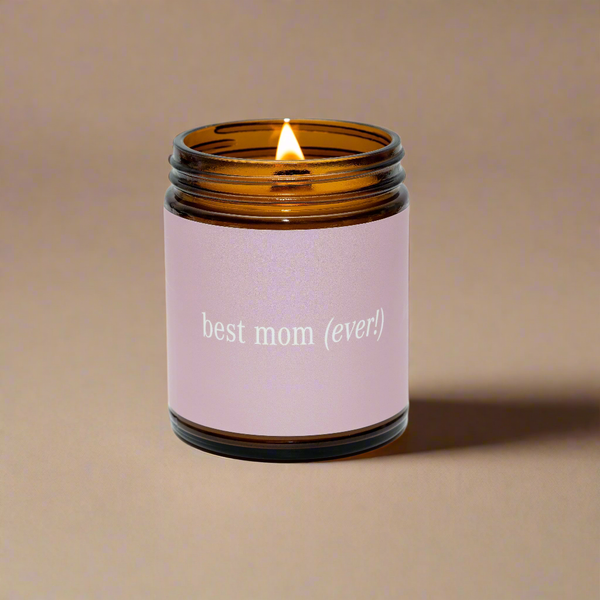 Candle in an amber jar with a pink label reading &