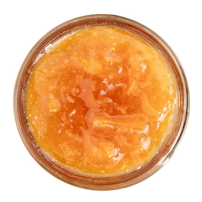 Jar of orange jam on a white background