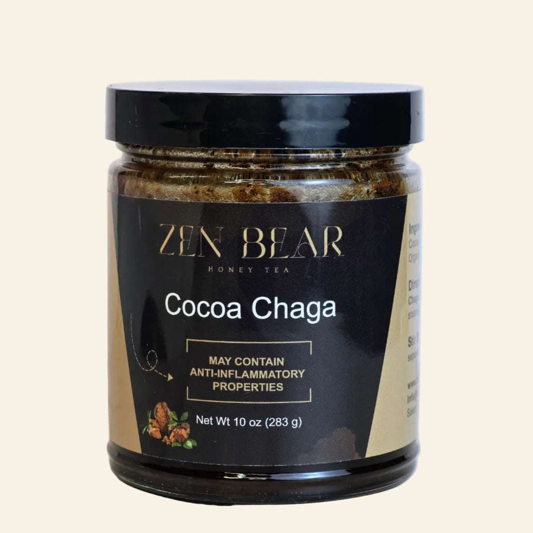 A jar of Zen Bear Honey Tea Cocoa Chaga, featuring a black lid and a black and beige label with gold lettering, set against a solid off-white background.