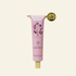 Pink hand balm tube with floral design on a white background