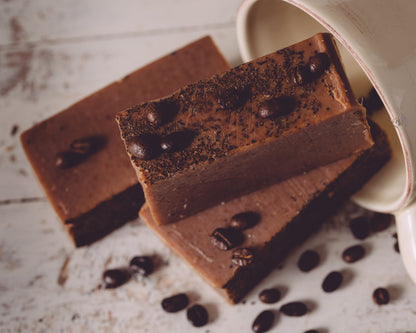 Chocolate soap bars with coffee beans on a textured surface