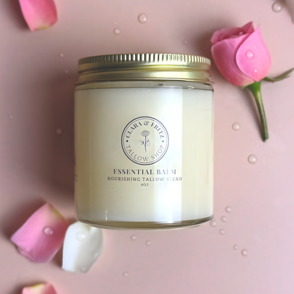 Jar of essential balm with a gold lid on a pink background with pink flowers.