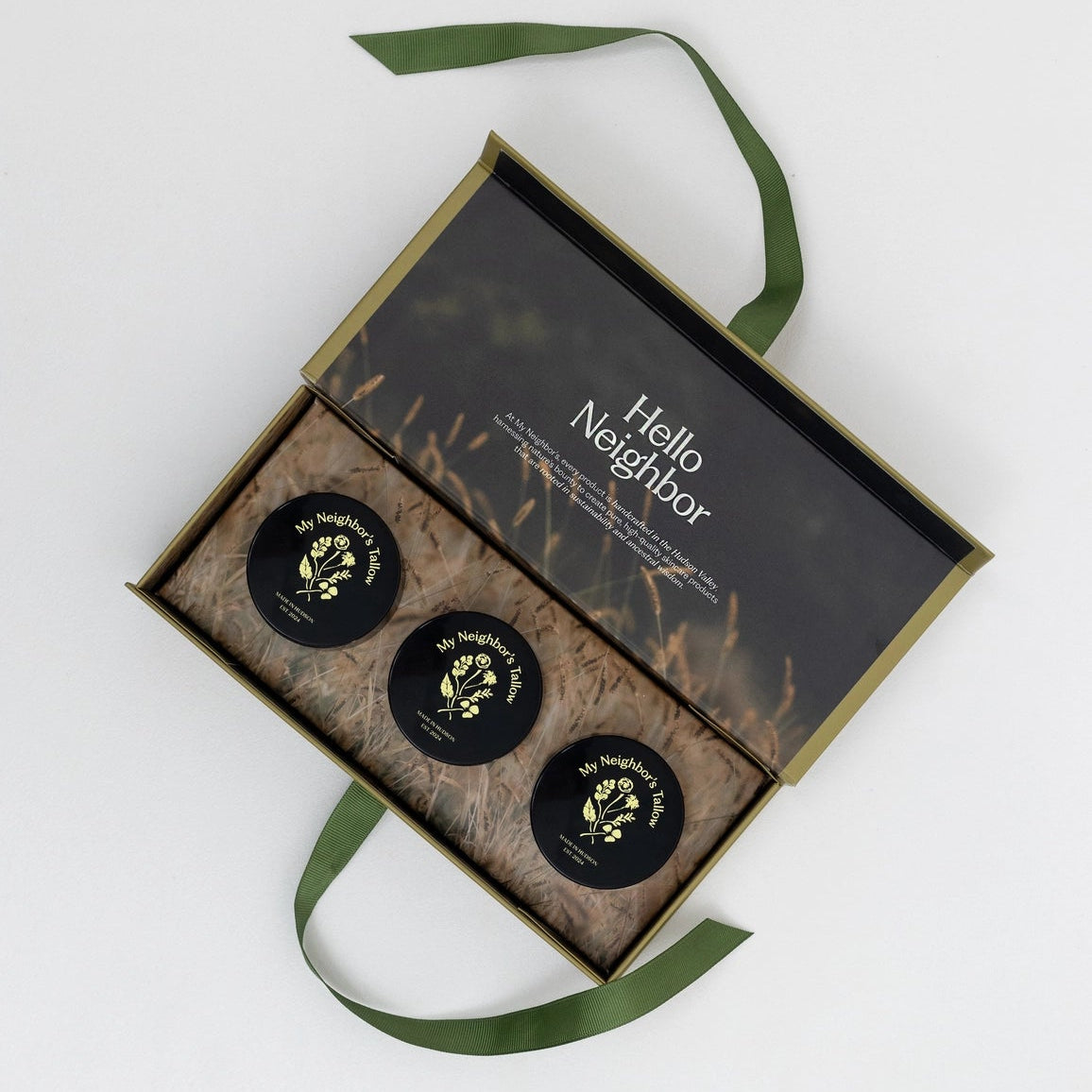 Three black containers with gold labels in a decorative box labeled &