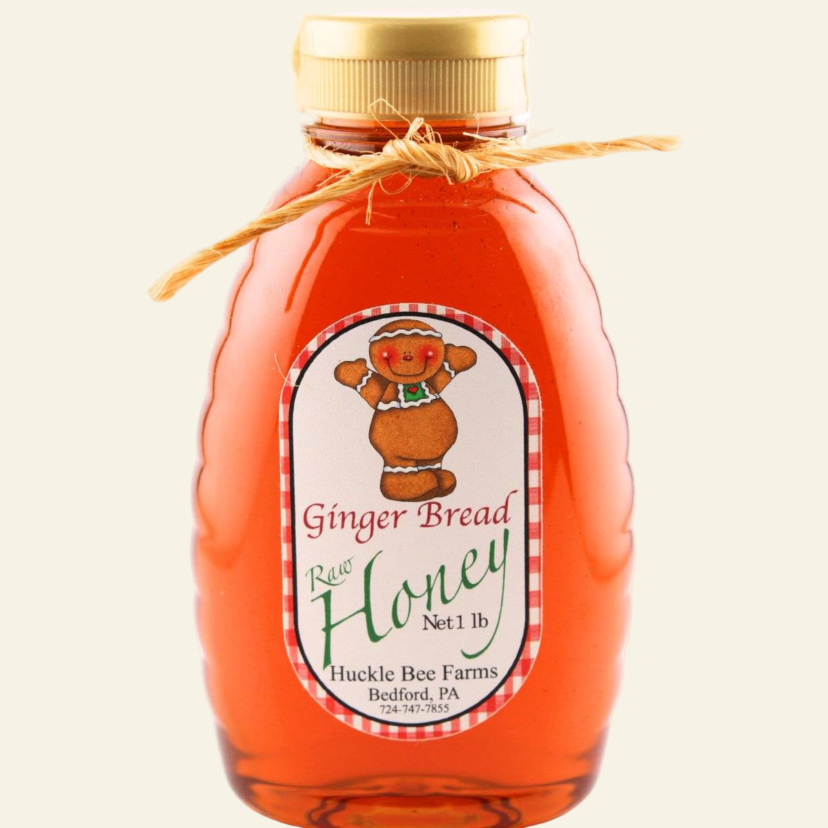 Bottle of gingerbread raw honey with a label on a white background