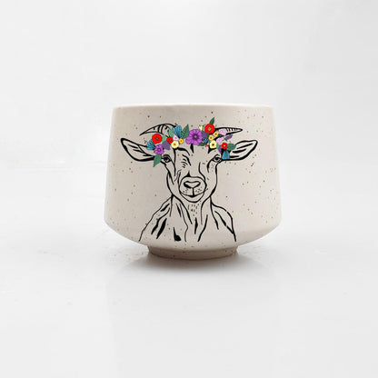 Ceramic pot with a goat illustration and floral crown on a white background