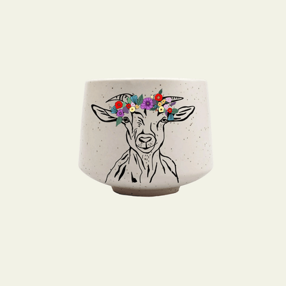 Ceramic pot with a goat illustration and floral crown on a beige background