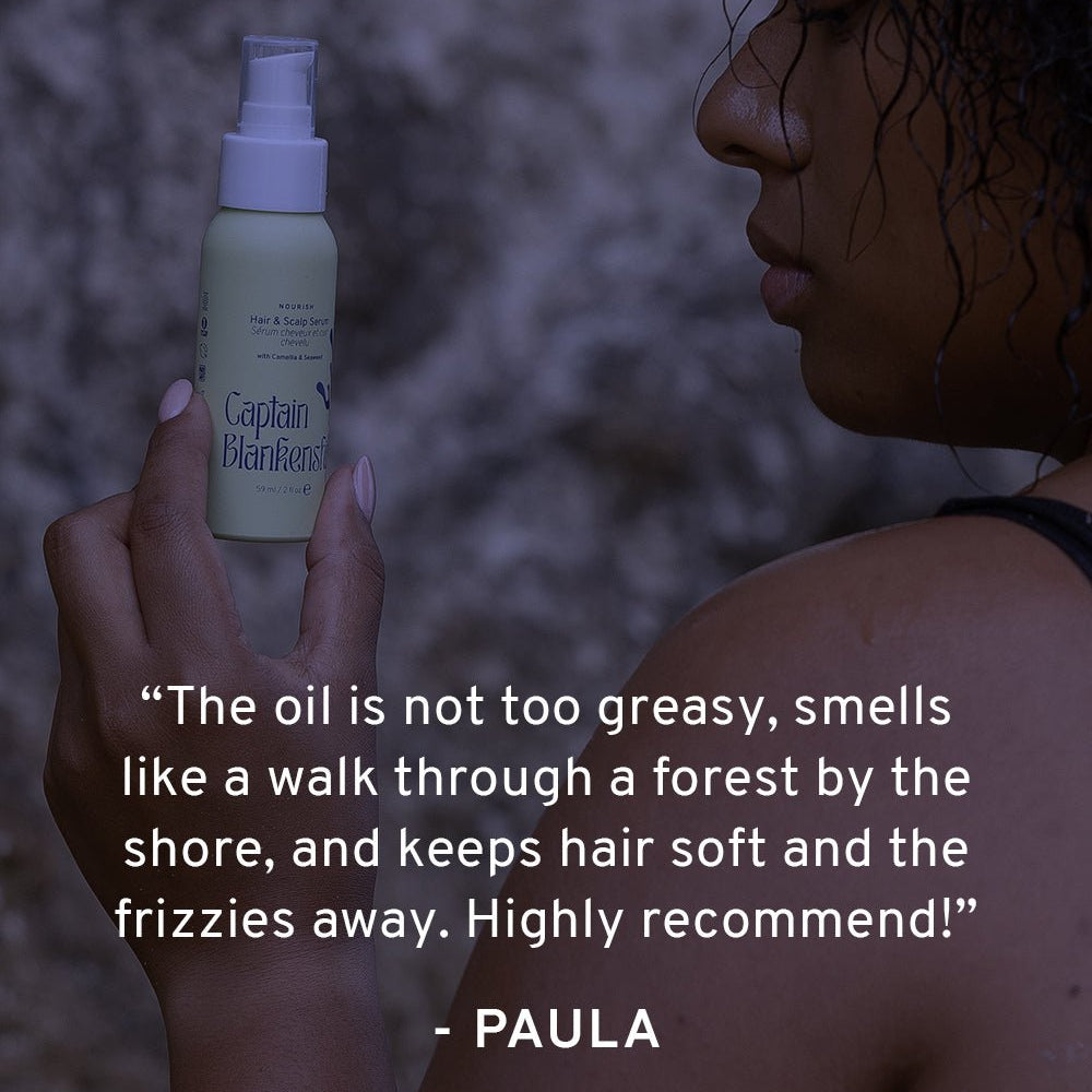 Person holding a bottle of Captain Blankenship hair oil with a quote from Paula on a dark background
