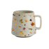 A speckled off-white ceramic mug with a handle, decorated with a pattern of colorful autumn leaves in orange, yellow, green, and red.