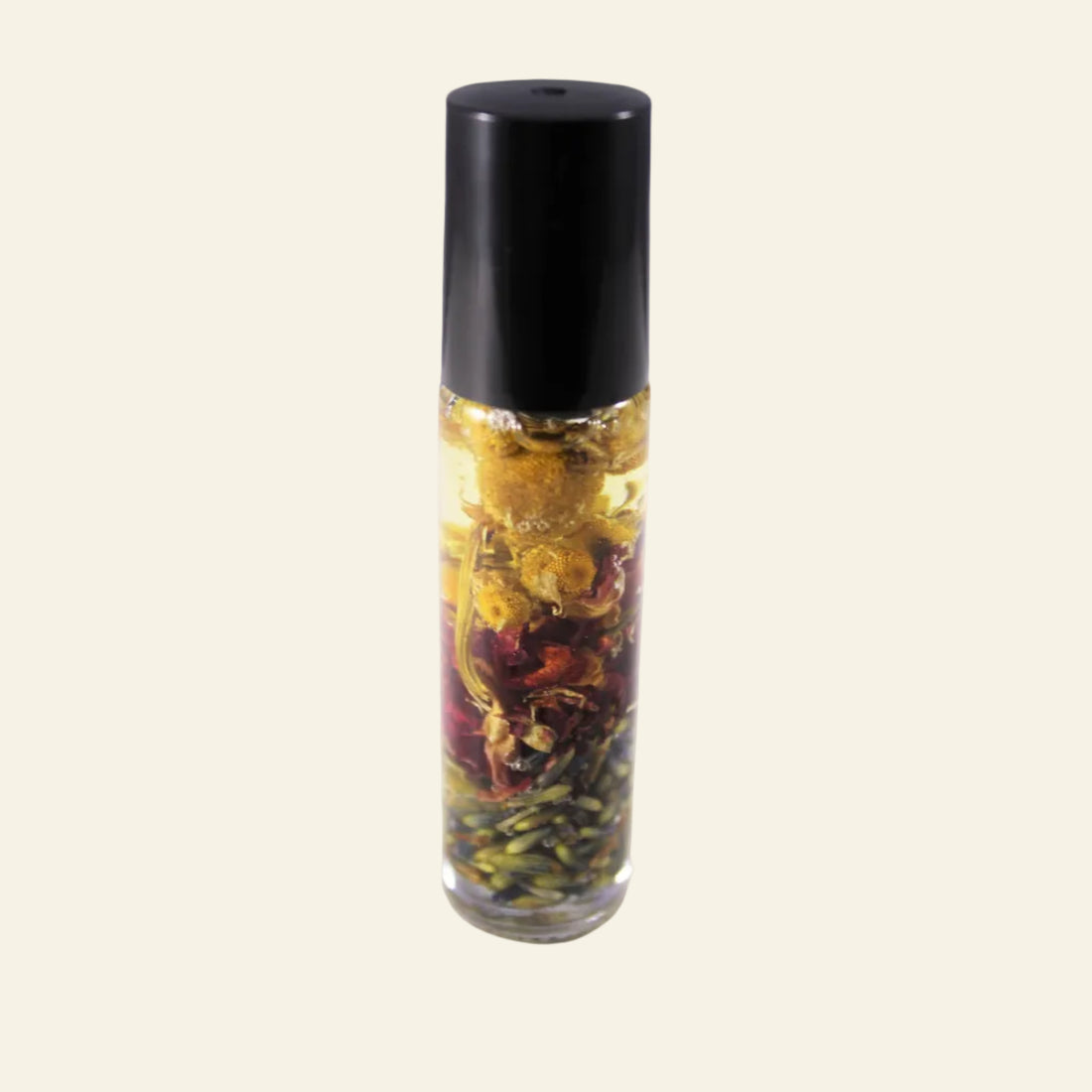 Glass roller bottle with black cap containing dried herbs on a white background