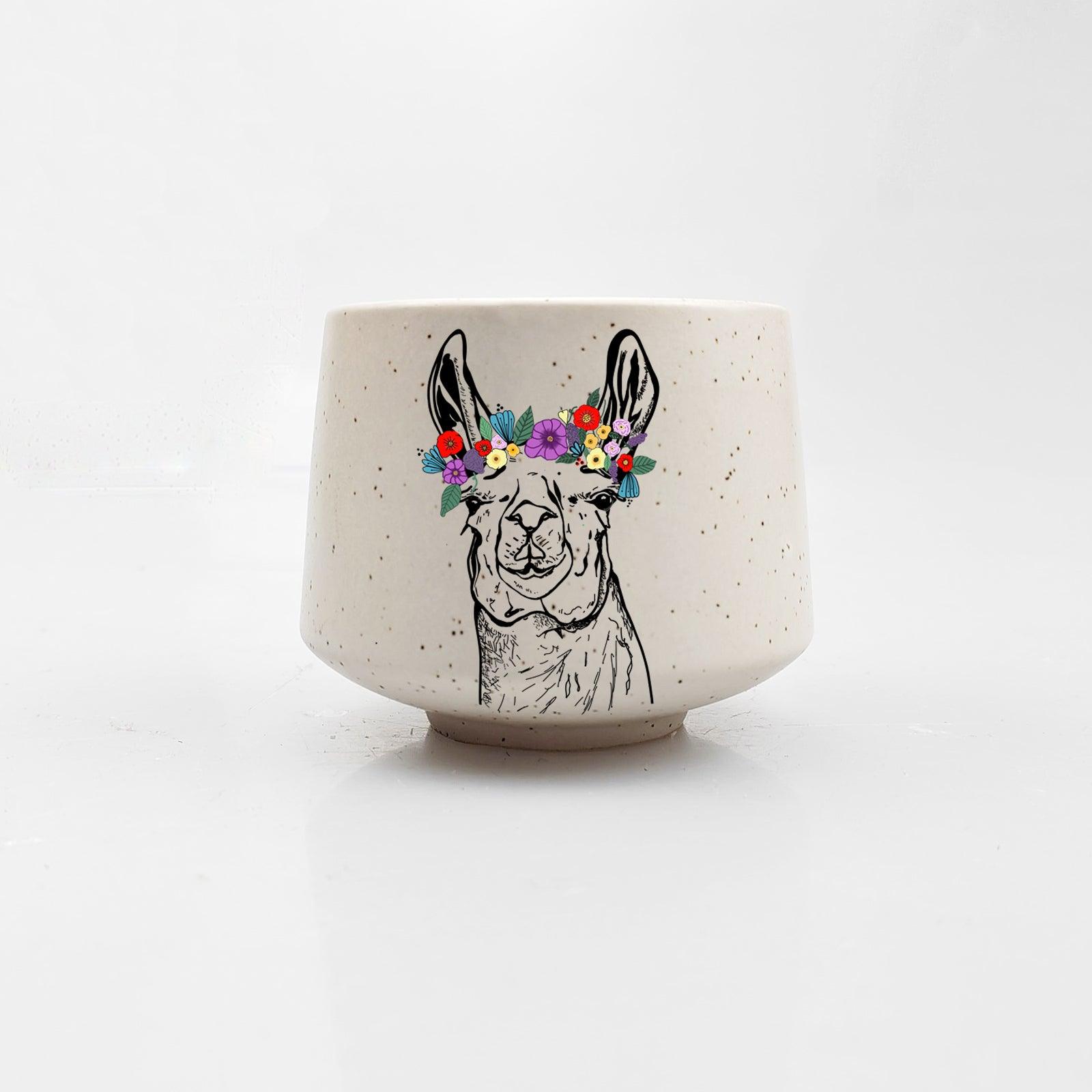 Ceramic cup with a llama illustration and floral crown on a white background