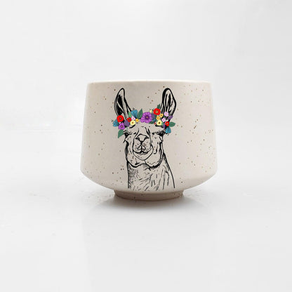 Ceramic cup with a llama illustration and floral crown on a white background