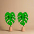 Green leaf-shaped earrings on a white background