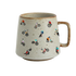 A speckled beige ceramic mug with a brown handle and rim, decorated with a playful pattern of small cartoon mountain bikers in various colorful outfits.
