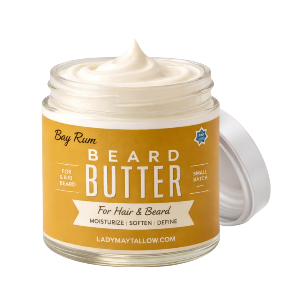 A jar of Lady May Tallow Bay Rum Beard Butter with a white cream product visible inside and a white lid leaning against it, set against a plain white background.