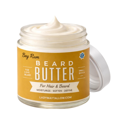 A jar of Lady May Tallow Bay Rum Beard Butter with a white cream product visible inside and a white lid leaning against it, set against a plain white background.