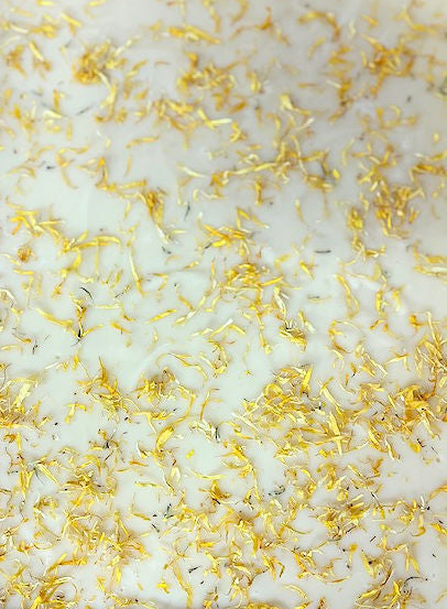 White bath bomb scrub with gold flecks on a white background