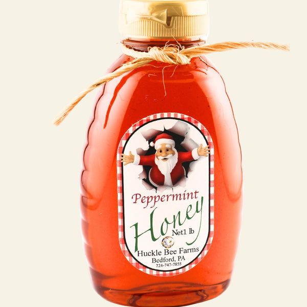 Bottle of peppermint honey with a Santa Claus label on a white background