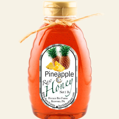 Bottle of pineapple raw honey with a label on a white background