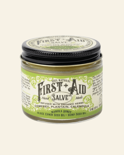 Jar of First Aid Salve with green and black label on a white background