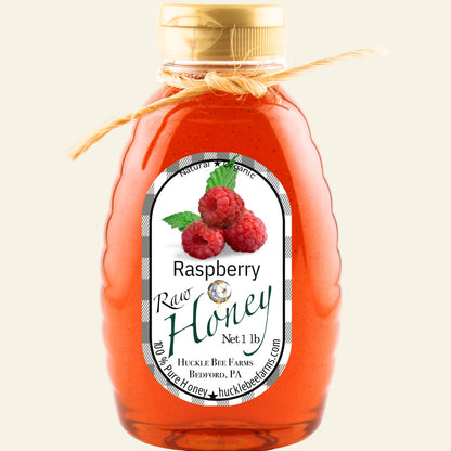 Bottle of raspberry honey with a label on a white background