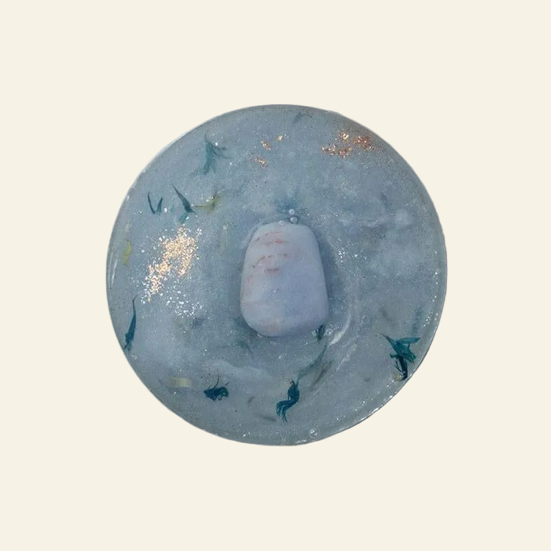 Round blue stone with embedded smaller stones on a white background