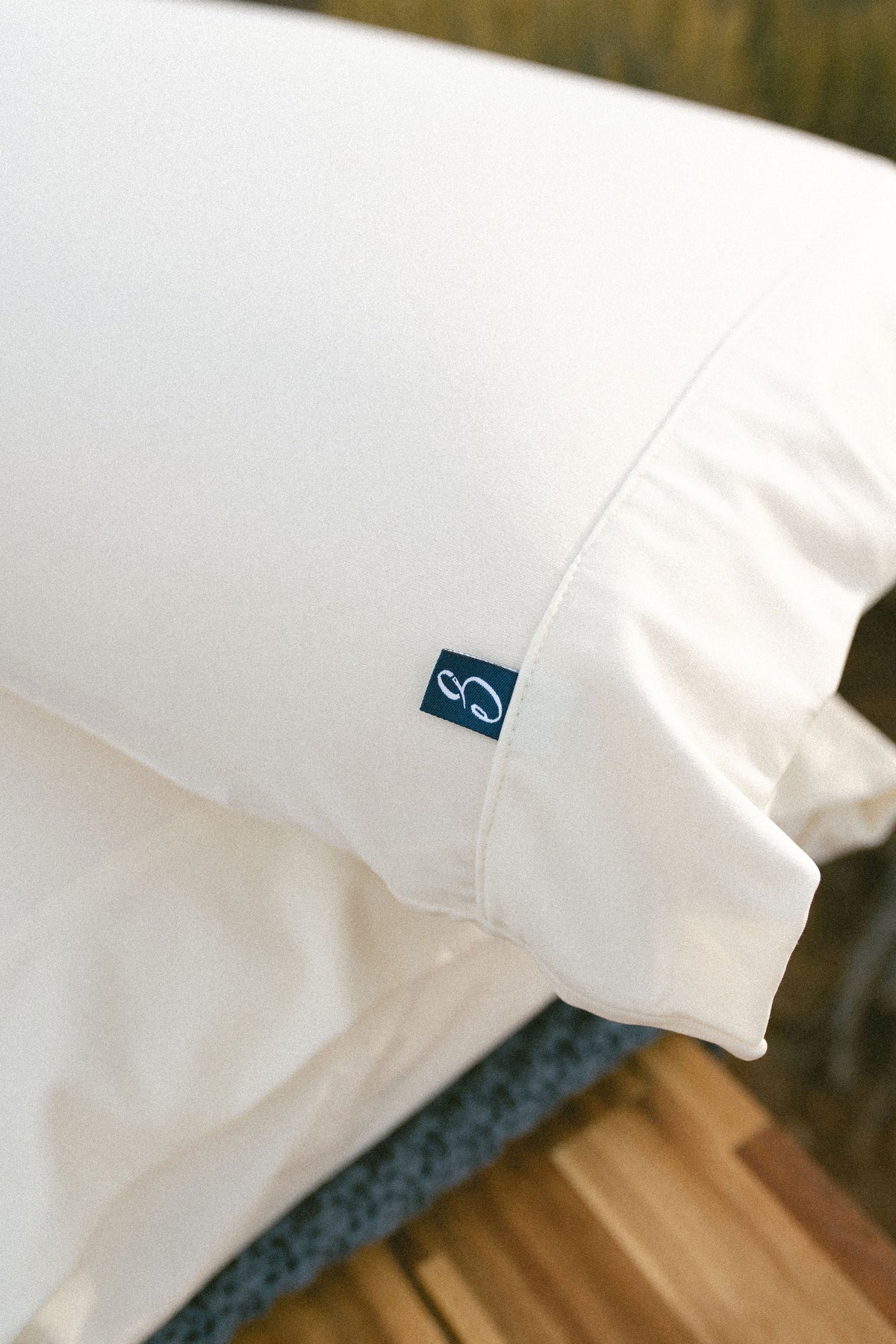 Close-up of a white pillow with a brand logo on a blurred background