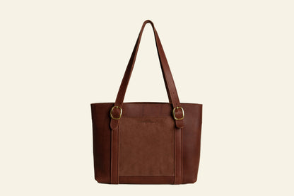 Brown leather tote bag with gold buckles on a white background