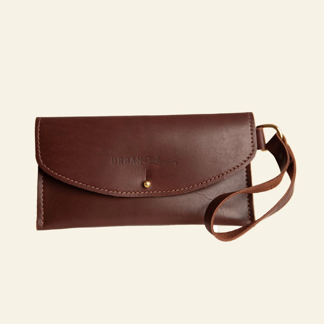 Brown leather clutch bag with strap on a white background