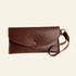 Brown leather clutch bag with strap on a white background