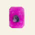 A bright pink rectangular gemstone with a small dark purple inlay in the center, displayed on a light gray marble surface.