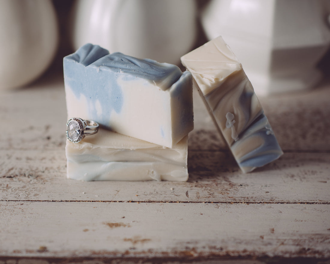 Two marbled soap bars on a wooden surface with a blurred background