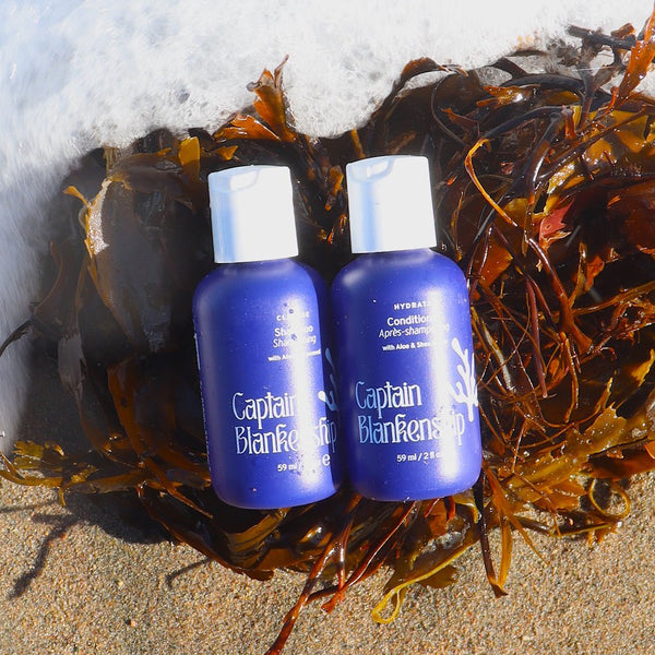 Two bottles of Captain Blankenfish shampoo and conditioner on a green background