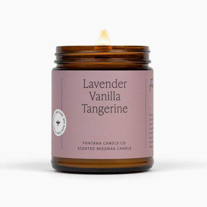 Lavender Vanilla Tangerine candle in an amber jar with a purple label on a white background