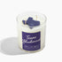 A white soy wax candle in a clear glass jar with a purple label reading &