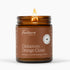 A lit Fontana Candle Co. Cinnamon Orange Clove scented beeswax candle in an amber glass jar with a brown label, set against a clean white background.
